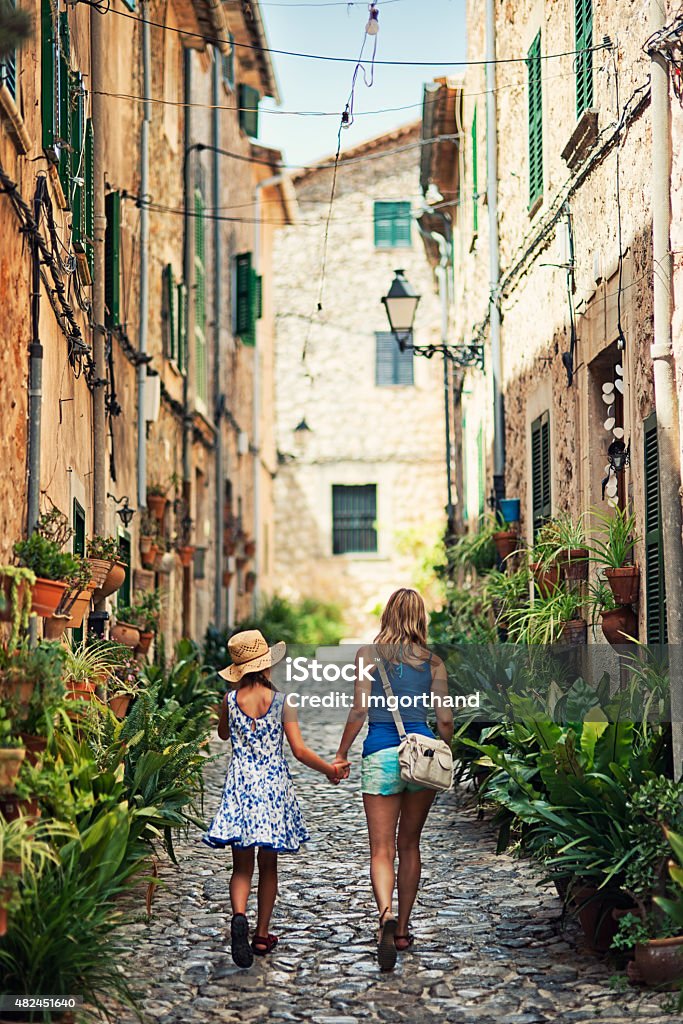 Mother and daughter visiting mediterranean town of Valldemossa Mother and daughter walking beautiful street of a mediterranean town. Valldemossa, Mallorca, Spain. Slightly soft. City Stock Photo