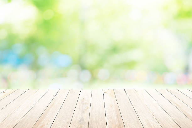 istock Green abstract blur nature background with wooden floor 482452566