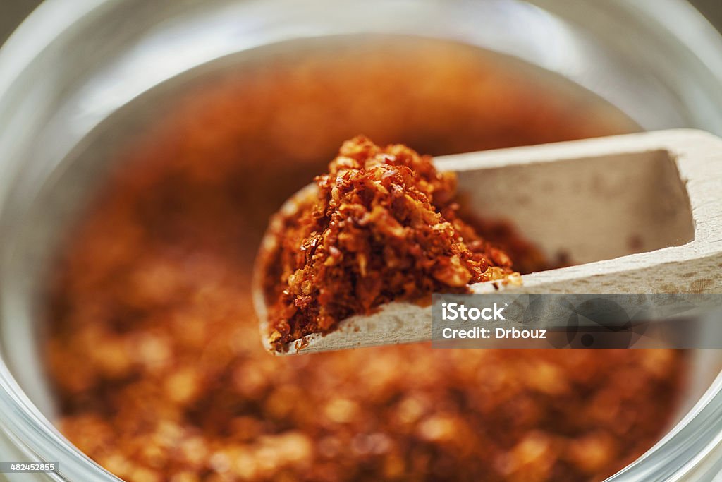 Ground red chili pepper Ground red chili pepper in glass dish with wooden teaspoon; extreme close up; selective focus; Cayenne Powder Stock Photo