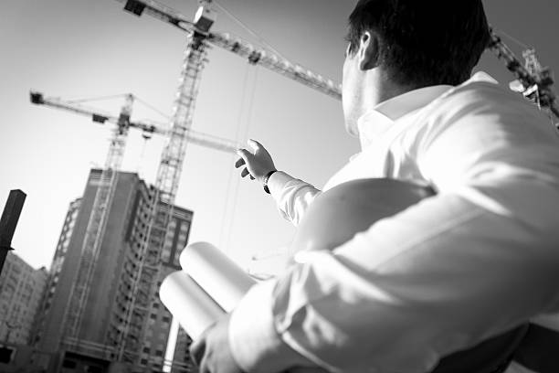 istock Black and white closeup of engineer pointing at the building 482453578
