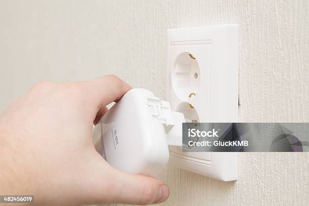 Insert Charger Into Wall Outlet Stock Photo - Download Image Now - Adult, Battery, Close-up