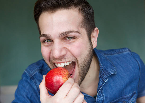 istock Healthy young man eating apple 482456173