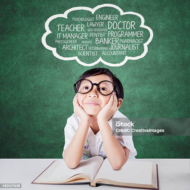 Child With Book Dreaming Future Jobs Stock Photo - Download Image Now - Child, Day Dreaming, Dreamlike