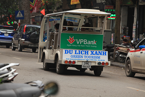 Hanoi, Vietnam - March 15, 2015: An electric vehicle serving tourist a 'green tour' around the old quarter street of Hanoi and Hoan Kiem (Sword) lake. 