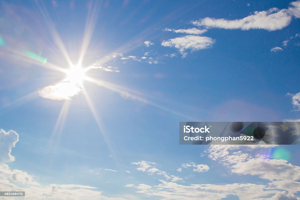 natural lens flare and radiating rays natural lens flare and radiating rays in a blue sky with clouds 2015 Stock Photo