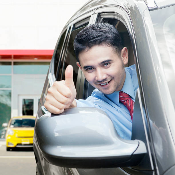 istock New car owner shows thumb up 482460802
