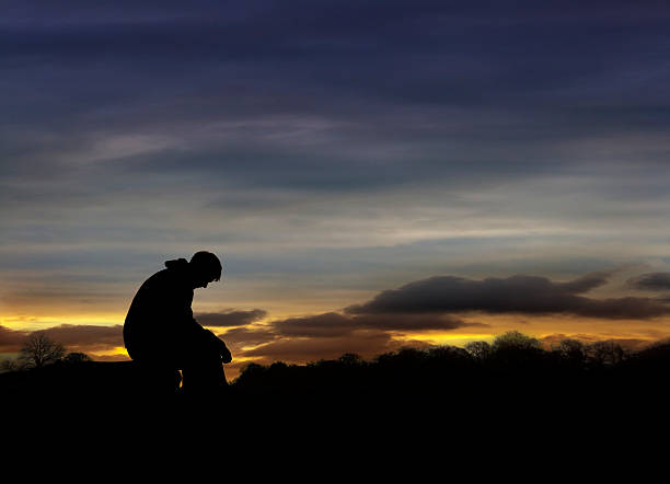 Sad man sitting in sunset stock photo