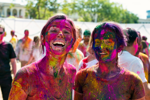 Jaipur, India - March 17, 2014: Two girl who covered with paint are enjoying at the Holi Festival. Holi is a spring festival also known as the festival of colours and the festival of love. Holi festival has an ancient origin and celebrates the triumph of 'good' over 'bad'. The colorful festival bridges the social gap and renew sweet relationships. On this day, people hug and wish each other 'Happy Holi'. People spend the day smearing and throwing colored powder all over eachother's faces-bodies, having parties and dancing. Photo was taken in public area