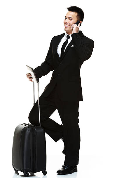 istock Businessman talking on mobile & holding trolley bag 482462029