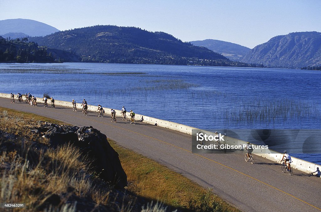 Triathlon Cyclists Triathletes competing in a triathlon ride their bikes on a sunny morning. Cycling Stock Photo