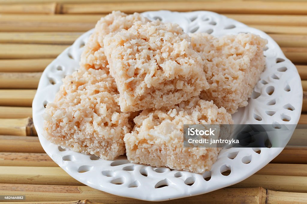 Coconut candy cocada Coconut candy cocada on vintage white plate on bamboo. Selective focus 2015 Stock Photo