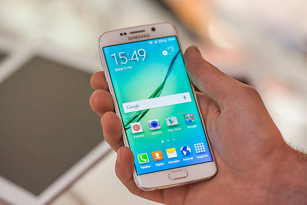 Samsung Galaxy S6 Edge in hand New York, USA - July 26, 2015: White Pearl colored Samsung Galaxy S6 Edge smartphone in hand in a tecknomarket.Samsung Galaxy S6 is supported with 5.1" touch screen display and 1440 x 2560 pixels resolution. product designer photos stock pictures, royalty-free photos & images