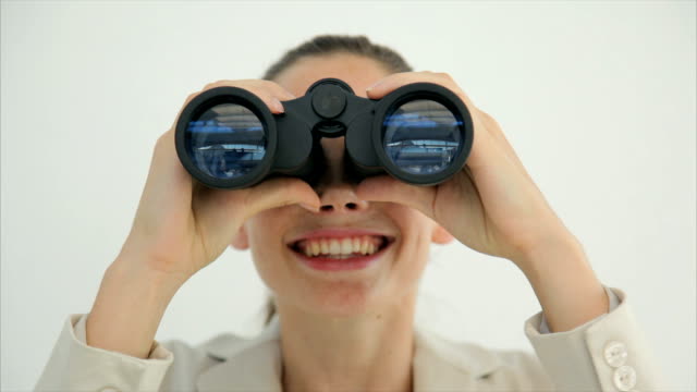 Young businesswoman looking through binoculars