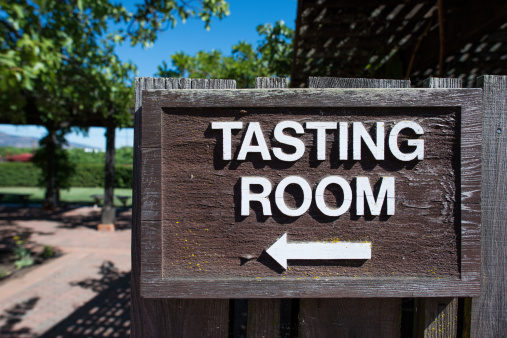 Directional sign pointing to wine tasting room in Napa, California.