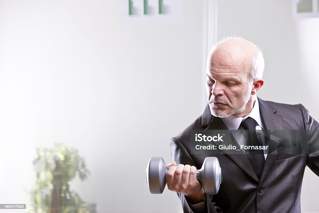weightlifting business man in action weightlifting business man in action looking at his shot Achievement Stock Photo