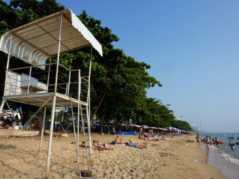 Jomtien, Thailand - January 01, 2014: Locals and tourist sunbathing and relaxing at Jomtien beach, a popular tourist resort near Pattaya.