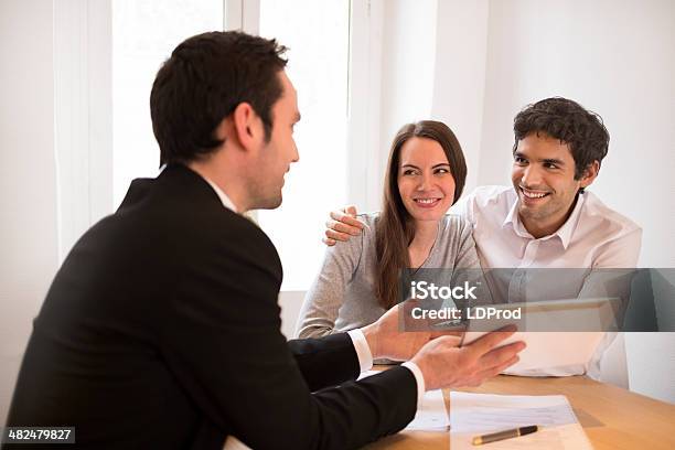 Young Couple Meeting Realestate Agent To Buy Property Presentation Tablet Stock Photo - Download Image Now