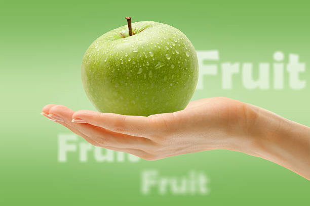 istock Female hand with green apple 482480302