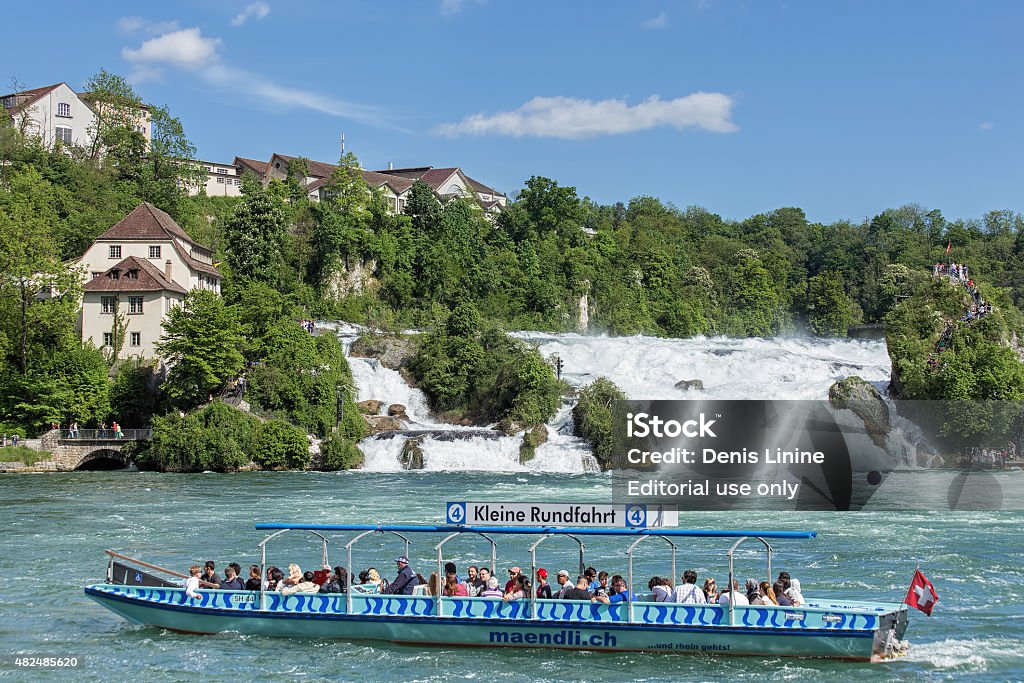 Rhine Falls Neuhausen am Rheinfall, Switzerland - 10 May, 2015: tourists in the boat near the Rhine Falls waterfall. The Rhine Falls is the largest plain waterfall in Europe, located on the Rhine river between the municipalities of Neuhausen am Rheinfall and Laufen-Uhwiesen, near the town of Schaffhausen in northern Switzerland, between the cantons of Schaffhausen and Zurich. 2015 Stock Photo