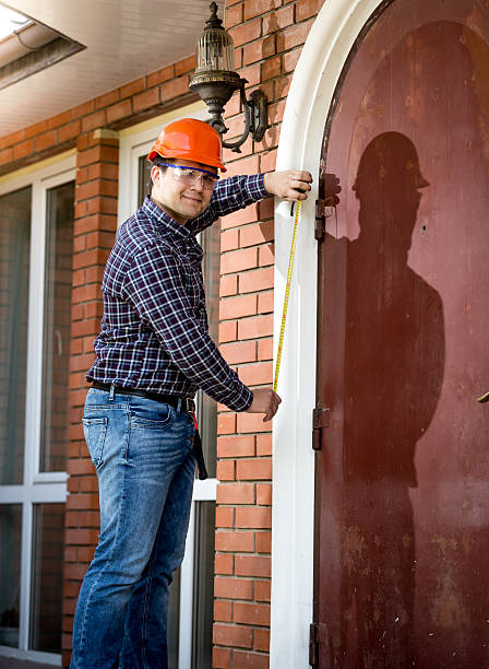 istock young carpenter measuring big metal door 482485922