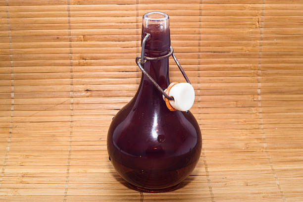 круглые, стеклянная бутылка с свободный топ изолированные на деревянном фоне - insulated drink container hip flask alcohol brown стоковые фото и изображения