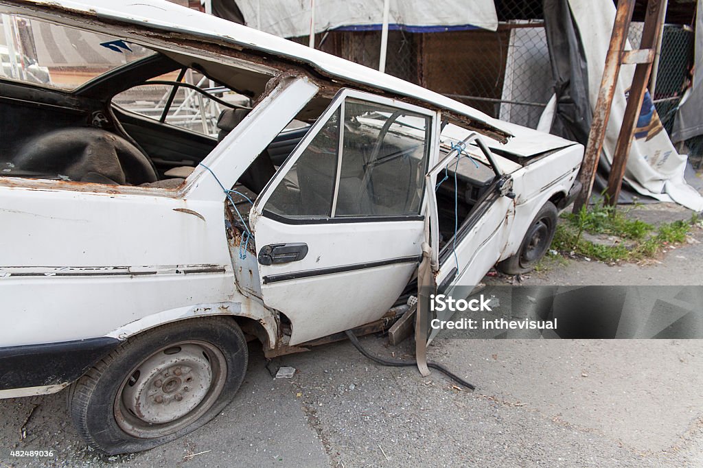 Abandoned Wrecked Old Car close up shot of a white wrecked old car on the street 2015 Stock Photo