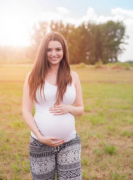 istock Pregnant woman standing on the meadow 482489706