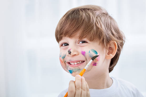 istock Little adorable child boy making a mess with colors 482490170