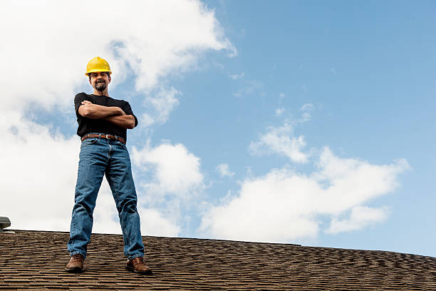 American Roofing Contractor Standing on Home Roof stock photo
