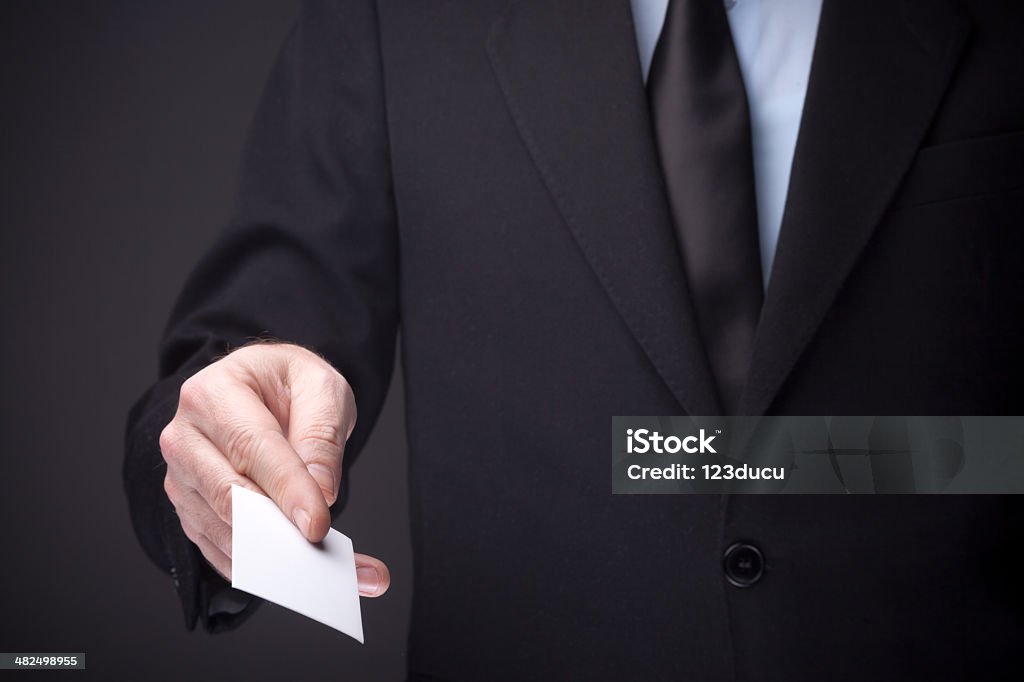 Business Meeting Businessman holding a blank business card isolated on gray Adult Stock Photo