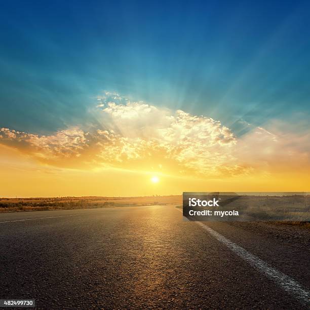 Asphalt Road And Sunset In Clouds Stock Photo - Download Image Now - Road, Sun, Sunlight