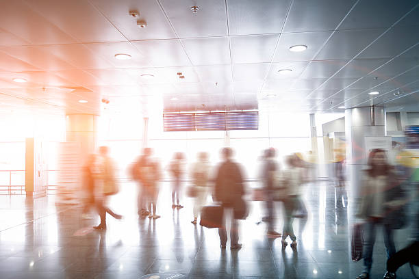 istock blurred passengers looking at airport schedule at sunny day 482500292