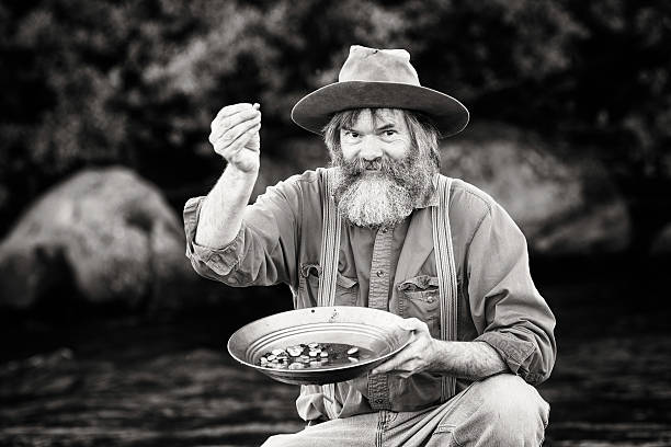 Gold rush prospector showing off his nuggets Gold rush prospector showing off his nuggets with enthusiasm. Sepia toned black and white image. panning for gold photos stock pictures, royalty-free photos & images