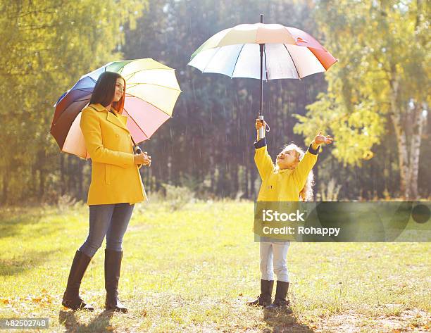 Family With Colorful Umbrella Having Fun Enjoying Weather In Aut Stock Photo - Download Image Now