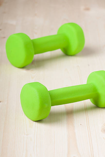 istock small green dumbbells on wooden surface 482503339