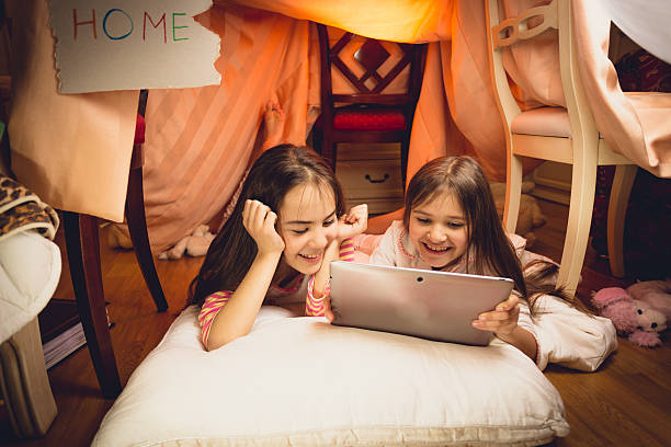 istock Happy girls using digital tablet in house made of blankets 482509502