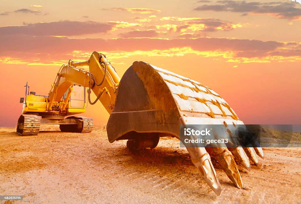 Excavator in sunset light. Cylinder Stock Photo