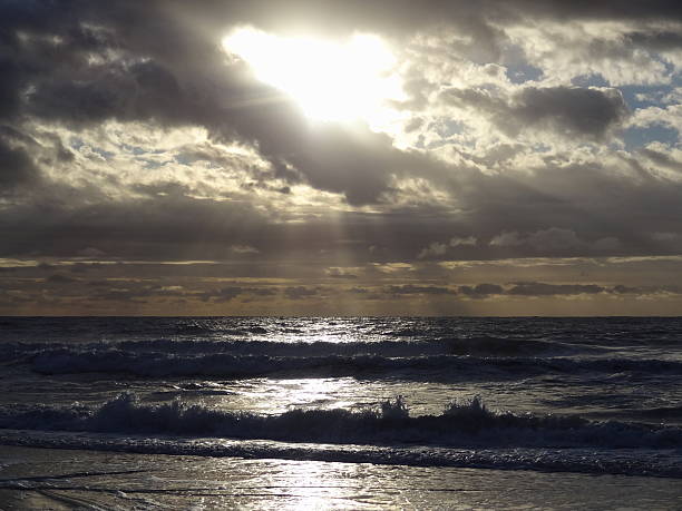 istock Sun breaking thru the Clouds at the beach 482516838
