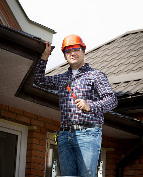 istock handyman standing on high ladder and inspecting house roof 482517274