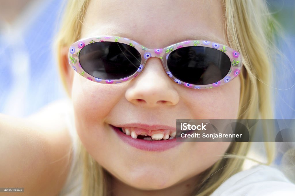 blond girl 1 closeup of a blond little girl with sunglases and tooth gap smiling cheerfully Beauty Stock Photo