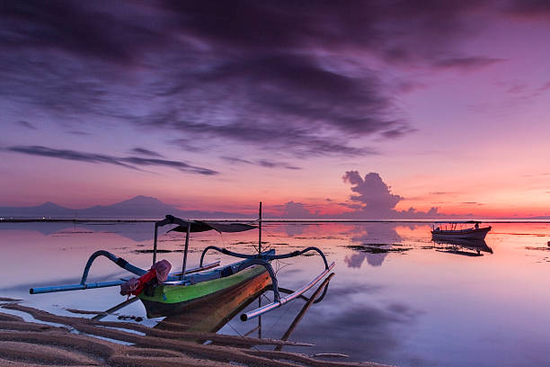 Dramatic sunrise in Bali with wooden boats stock photo