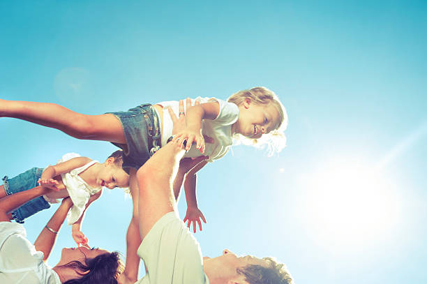 istock Mother and father lifting daughters in the air 482519531