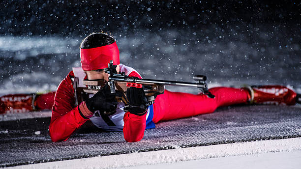 weibliche shooting at biathlon training bei nacht - biathlon stock-fotos und bilder