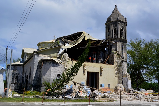 Dauis, Philippines - February 8, 2014: Church of Our Lady of the Assumption in Dauis, Bohol damaged by the strong earthquake occurred on October 15, 2013 in Bohol. In the background, some men working on the church ruins,