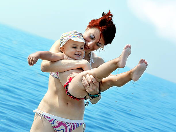 istock baby and mother in sea water 482524672