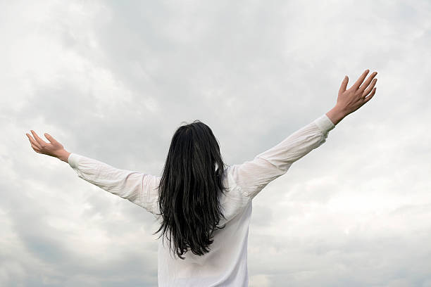 istock Young woman and clouds, arms stretched out 482527122