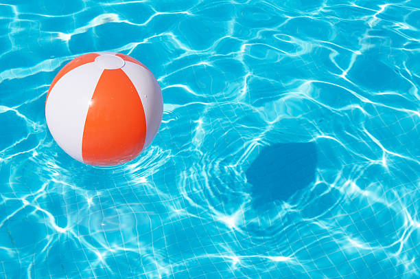 istock Colorful beach ball floating in a pool 482529484