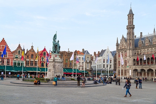 Bruges, Belgium - March 27, 2014: The main square or La Grand Place in Bruges, Belgium. Bruges became a UNESCO World Heritage site in 2000 and is a popular travel destination.