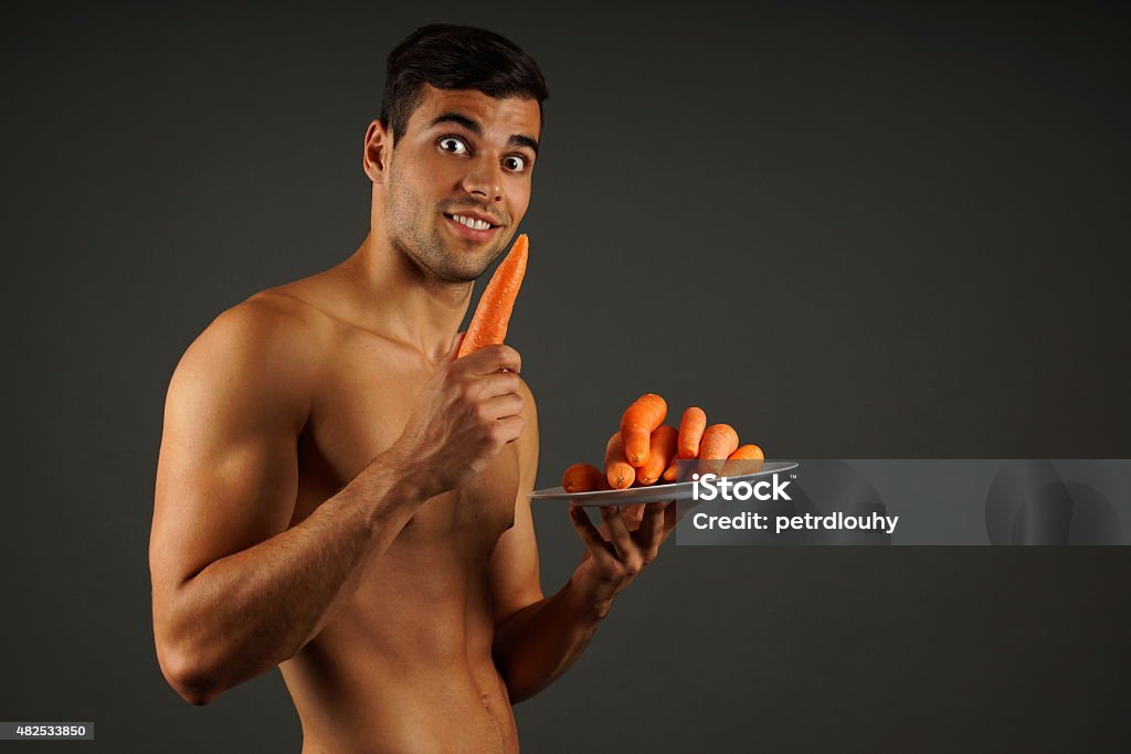 Young man with carrots Surprise young man with carrots on the plate 2015 Stock Photo