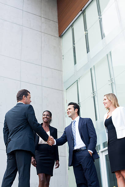 istock Business men shaking hands in front of building 482534827
